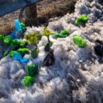 Plastic dog waste bags lying on the ground filled with dog poop, illustrating improper dog poop disposal practices and underscoring the need for effective pet waste management.