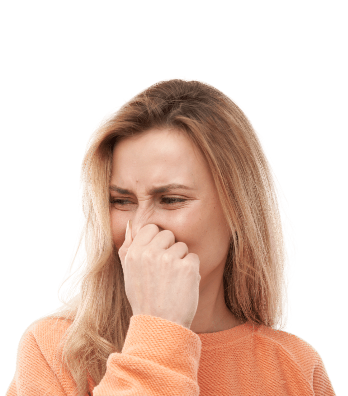 Woman holding her nose in a backyard, highlighting the need for yard deodorizing and dog odor removal services in Delaware.